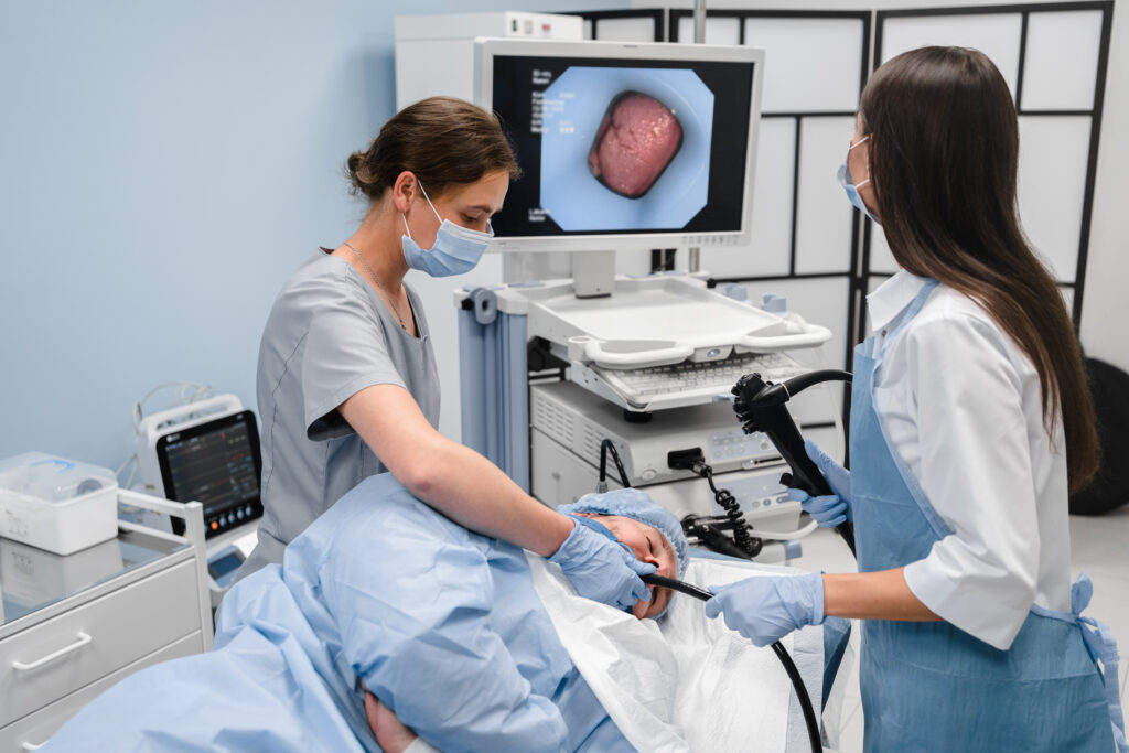 doctor using a fiberoptic scope at gastroscopy in modern operating room.